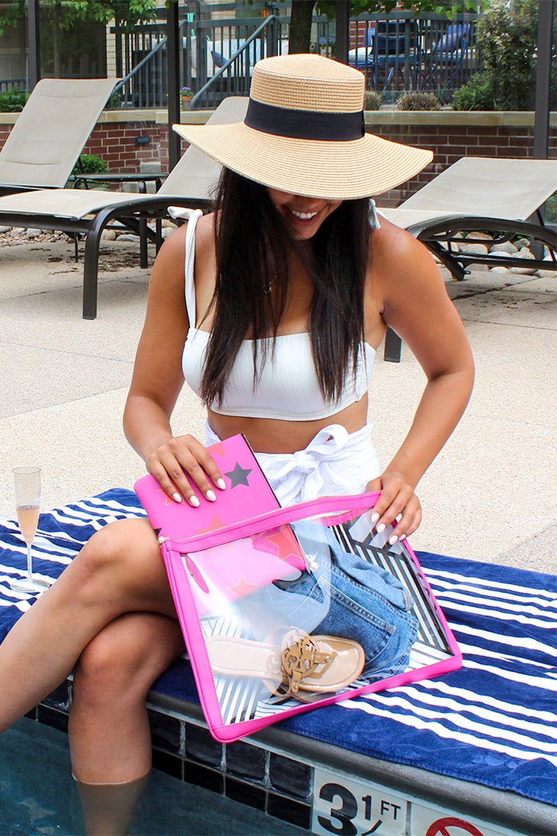 Woman sitting by the pool putting a smaller otg bag inside of a larger otg bag containing some clothing items.